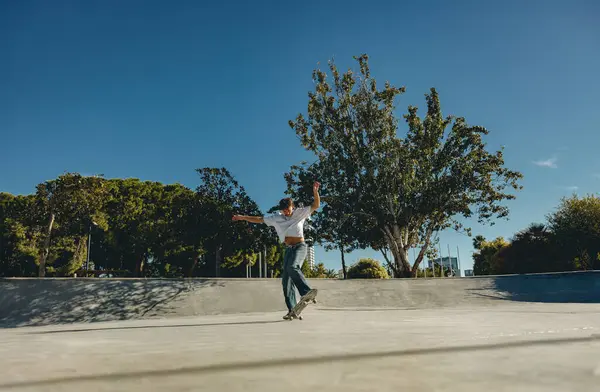 Kaykay parkında kaykay yaparken gündelik kıyafetli bir erkek kaykaycı vücudu.