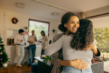 Gülümseyen arkadaşlar sarılırlar ve tatilde birlikte vakit geçirmenin tadını çıkarırlar. 