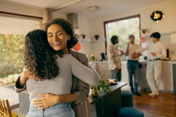 Mutlu genç bayan arkadaşlar evdeki tatil partisinde sarılıp eğleniyorlar.