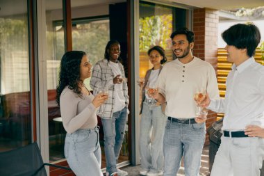 Mutlu arkadaşlar sohbetten ve ev partisinde şenlik yemeği sırasında şarap içmekten zevk alırlar.