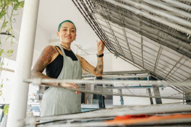 Önlüklü kadın işçi tasarım stüdyosunda çalışırken özel ekipman kullanır. Yüksek kalite fotoğraf