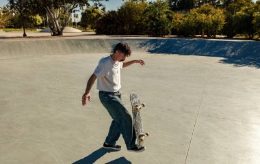 Güneşli bir günde kaykay parkında kaykay yapan aktif bir genç. Ekstrem spor konsepti