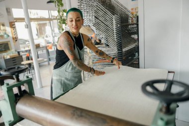 Önlüklü kadın işçi tasarım stüdyosunda çalışırken özel ekipman kullanır. Yüksek kalite fotoğraf