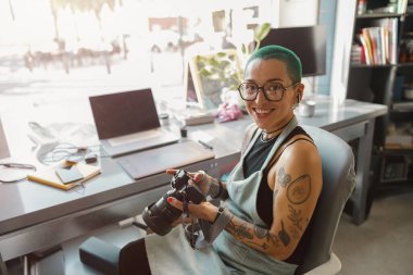 Gözlüklü kadın tasarımcı kendi tasarım stüdyosunda çalışırken kamera kullanıyor. Yüksek kalite fotoğraf