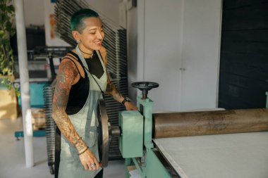 Önlüklü kadın işçi tasarım stüdyosunda çalışırken özel ekipman kullanır. Yüksek kalite fotoğraf