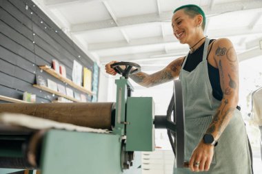 Önlüklü kadın işçi tasarım stüdyosunda çalışırken özel ekipman kullanır. Yüksek kalite fotoğraf