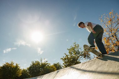 Kaykay parkında kaykay yapan genç bir adam. Etkin spor konsepti