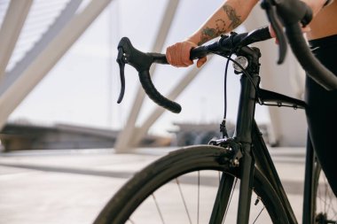 Bisiklete binmeden önce bisikletle duran kadın bisikletçiye yaklaş.