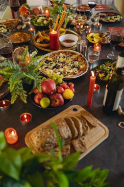 Arkadaşların ev partisi için hazırlanmış farklı lezzetli yiyecek ve içeceklerle rahat bir tatil sofrası.