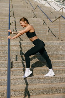 Spor kıyafetli genç bayan sporcu sabah koşusundan sonra dinleniyor.