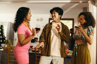 Mutlu arkadaşlar sohbetten ve ev partisinde şenlik yemeği sırasında şarap içmekten zevk alırlar.