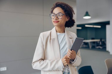 Modern çalışma arka planında dijital tabletli neşeli kadın serbest yazar 