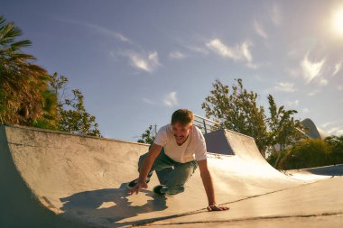 Güneşli bir günde kaykay parkında kaykaya binen genç bir adam. Ekstrem spor konsepti