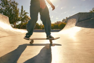 Kaykay parkındaki kaykayıyla numaralar yapan genç adama yaklaş. Etkin spor konsepti