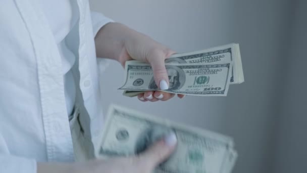 一张清晰的图片显示了一个女人的双手 她提供了一叠100美元的钞票 突出了金融交易和现金管理 — 图库视频影像