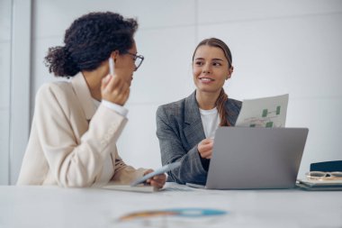 İki kadın profesyonel yönetici mali muhasebe belgelerini tartışıyorlar. 