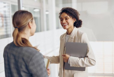 Mutlu kadın ofis çalışanlarının dikkati dağılıyor ve tatilde ofiste konuşuyorlar.