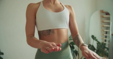 Yakından çekilen ve yoga pozunda tonlu kollarını gösteren bir fotoğraf. Güç, zarafet ve kontrol üzerine odaklanılır. Sakinleştirici ve minimalist bir geçmişe karşı hazırlanır..