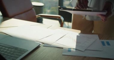 Odaklanmış veri analizi, stratejik planlama ve profesyonel bir ortamda karar verme mekanizmasını temsil eden, iyi aydınlatılmış bir ofisteki bir masanın mali tablolarını inceleyen ellere yakından bir bakış.