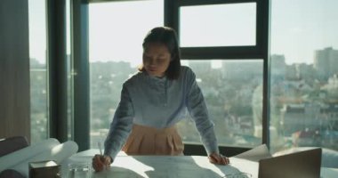 Profesyonel bir mimar, parlak ve çağdaş bir ofisin planlarını çizmeye odaklanır. Sahne hassasiyeti, yaratıcılığı ve şehir manzarasını gözler önüne seriyor.