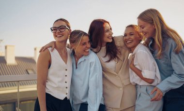 Beş yakın arkadaş, çarpıcı bir günbatımına karşı güzel bir şekilde yakalanmış, dışarıda keyifli ve keyifli bir anı paylaşıyor.