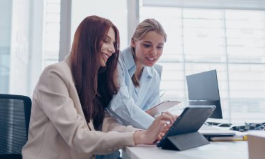 İki profesyonel çağdaş ofis ortamında tablet kullanarak verimli bir tartışmaya giriştiler..