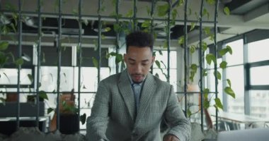 Kendini adamış bir profesyonel eleştirmen ve yeşil dekorlu modern bir çalışma alanında mimari planlar çiziyor. Görüntü yaratıcılığı, odaklanmayı ve detaylara dikkati iletir..