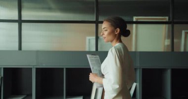Bir iş kadını, bir iş adamına dizüstü bilgisayarda açıklarken bir belgeye işaret ediyor. Modern ve profesyonel ofis alanlarında doğal ışıkla iş birliği yapıyorlar..