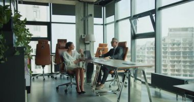 İki iş adamı, parlak ve modern bir ofiste karşılıklı oturup kahve fincanlarını alıp işi tartışırlar. Sahne, sakin bir profesyonellik ve takım çalışması içeriyor..