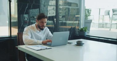 Parlak ofiste dizüstü bilgisayarda çalışan bir iş adamı. Yüksek kalite 4k görüntü