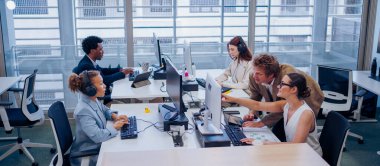 Takım çalışması ve işbirliği yapan profesyonellerle dolu hareketli ve dinamik bir ofis.