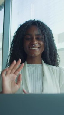 Kendinden emin genç bir kadın, parlak bir ofiste tutkulu bir şekilde konuşuyor. Yaratıcılık ve coşku sergiliyor..