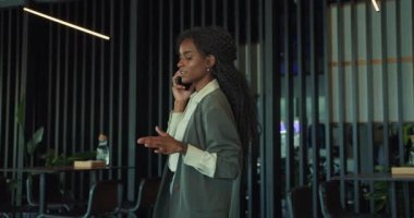 Hırslı bir kadın şu anda lüks, modern ofisinde önemli ve önemli bir telefon görüşmesi yapıyor.