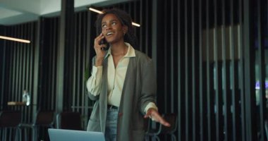 Modern bir ofiste odaklanmış bir kadın, profesyonelliğini ve uzmanlığını gösteren bir telefon görüşmesi yapmaktadır.