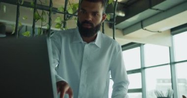 Kendini işine adamış ve odaklanmış bir profesyonel modern ofis ortamında anlamlı işler yapıyor.