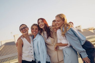 Beş neşeli kadın birlikte güneşli bir günün tadını çıkarıyorlar. Arkadaşlıklarını sergiliyorlar ve güzel anılar ediniyorlar.