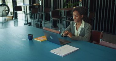 Kendini işine adamış ve işine odaklanmış bir profesyonel, bir dizüstü bilgisayarda detaylı bir şekilde çalışıyor.