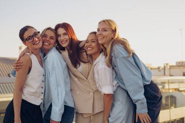Beş farklı kadın güneşli bir günde arkadaşlığı sevinçle kutluyor, birlikte pozitifliği kucaklıyorlar.