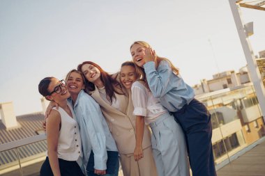 Neşeli ve hayat dolu bir arkadaş grubu çarpıcı bir günbatımı arkaplanına karşı keyifle eğleniyor.