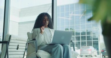 Kendini işine adamış ve odaklanmış bir kadın aktif olarak sanal bir toplantıya katılıyor.