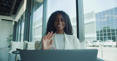 Kendine güvenen bir iş kadını enerji ve işbirliği dolu dinamik bir sanal toplantıya aktif olarak katılır.