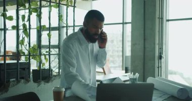 Odaklanmış bir profesyonel, modern ve işbirlikçi bir ofiste belgeleri incelerken önemli bir karar verir.