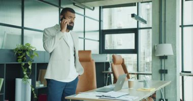 Son derece profesyonel bir şahıs şık ve modern ofis ortamında önemli bir telefon görüşmesi yapıyor.