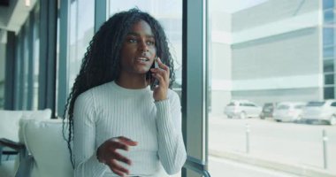 Profesyonel bir kadın, modern bir ofiste düşünceli ve odaklanmış bir ifade sergileyerek bir telefon görüşmesi yapar.