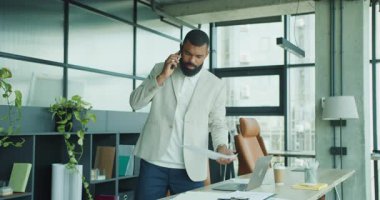 Bir iş adamı, çağdaş ve modern bir çalışma alanında anlamlı bir telefon görüşmesi yapmaktadır.