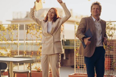 Neşeli ve hevesli bir ikili, canlı, modern bir açık hava ortamında inanılmaz iş başarılarını kutluyor.