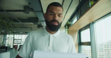 Yetenekli bir profesyonel adam modern ve şık bir ofis ortamındaki önemli belgeleri titizlikle inceler.