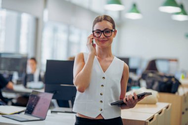 Profesyonel bir kadın, modern ve sofistike ofis ortamının altını çiziyor.