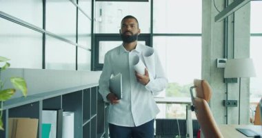 Kendini işine adamış ve işine odaklanmış bir profesyonel, çağdaş bir ofis ortamında çalışırken planlar taşıyor.