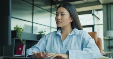 Şık, modern bir ofiste, genç bir profesyonel dizüstü bilgisayarla yazarken odak ve bağlılık gösteriyor. Yüksek kalite 4k görüntü